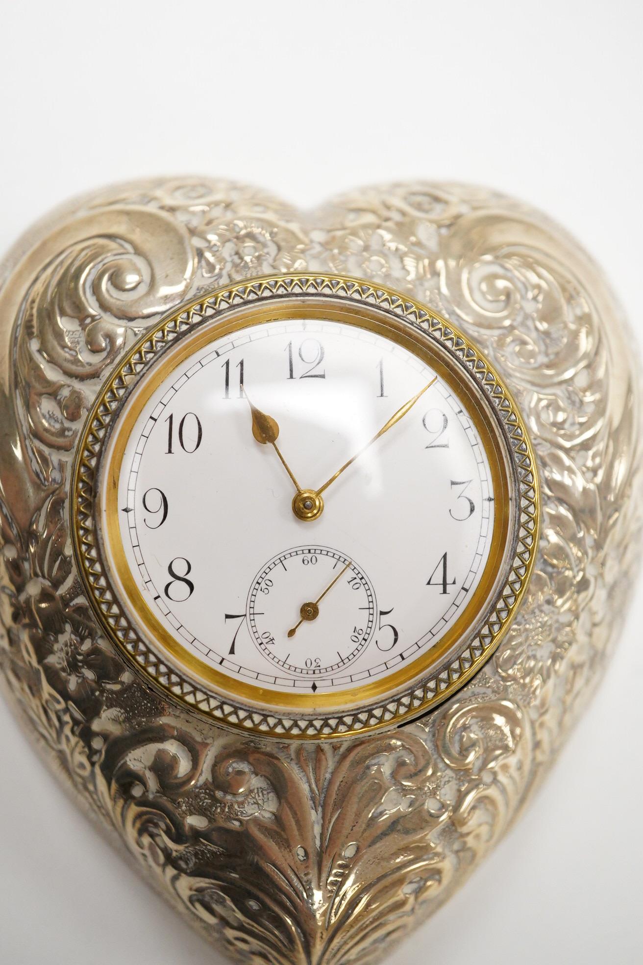 A late Victorian repousse silver mounted brass heart shaped bedside timepiece, with Arabic dial and subsidiary seconds, Douglas Clock Co. Birmingham, 1900, 94mm.
